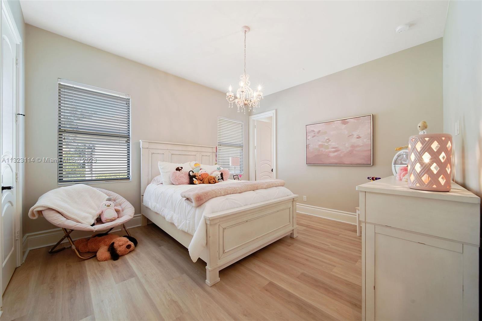 2863 Lake Ridge Lane Weston, FL 33332 - Photo 32 of 60 a bedroom with a bed and a chandelier