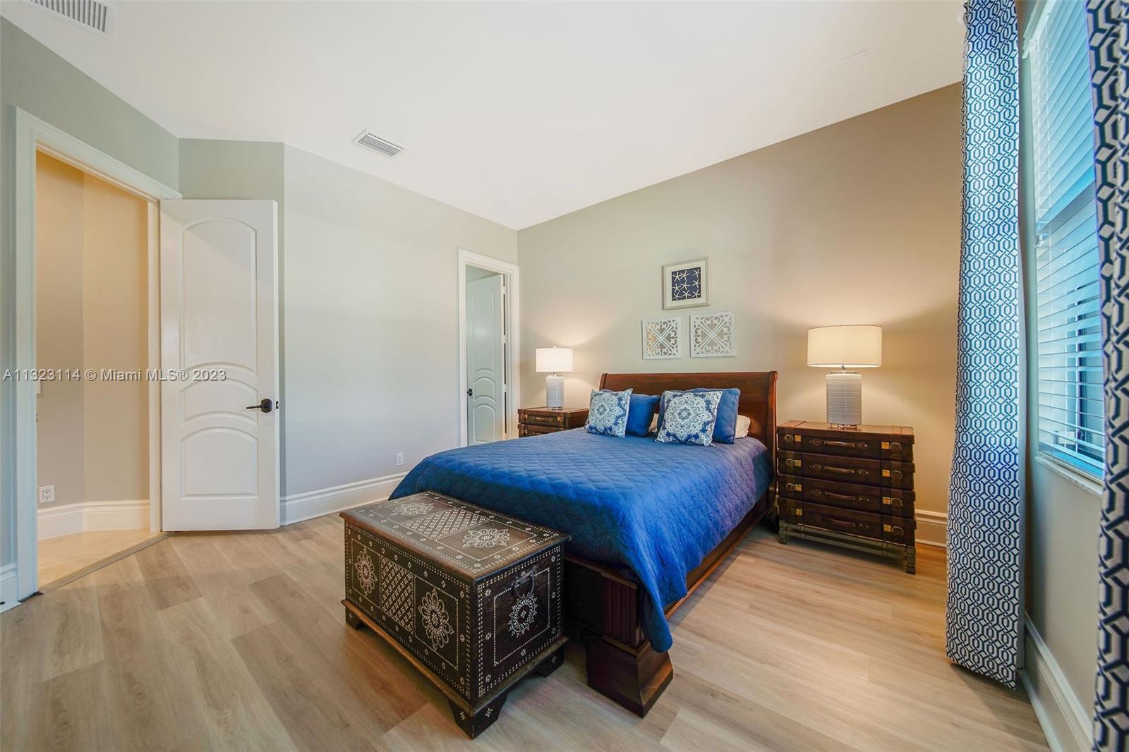 2863 Lake Ridge Lane Weston, FL 33332 - Photo 35 of 60 a bedroom with a bed and a table