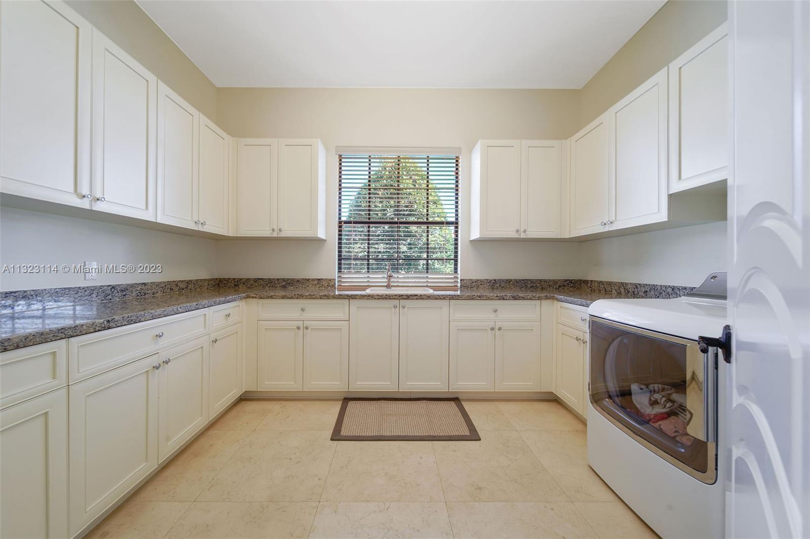 2863 Lake Ridge Lane Weston, FL 33332 - Photo 37 of 60 a kitchen with granite countertop a stove sink and cabinets