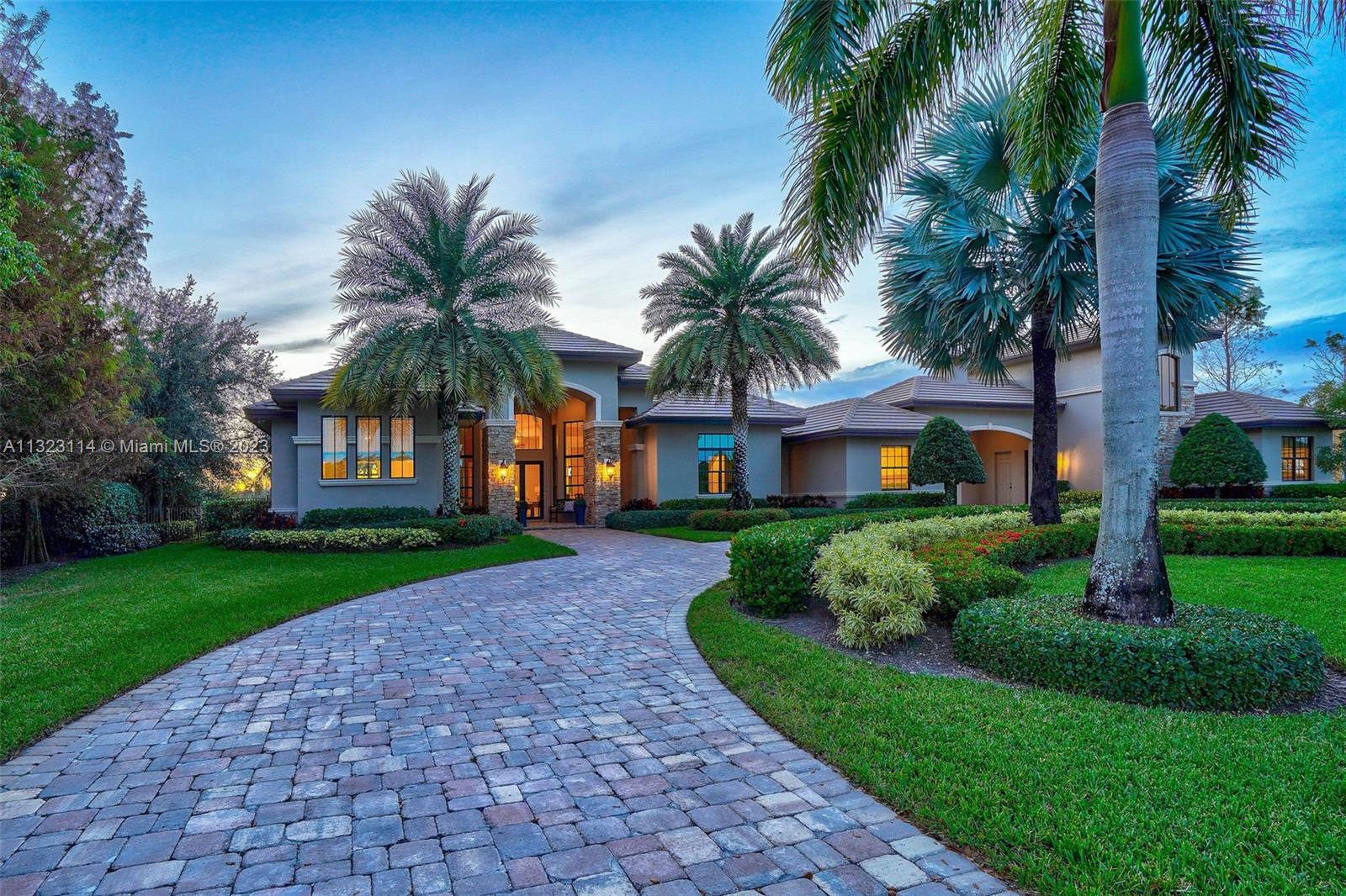 2863 Lake Ridge Lane Weston, FL 33332 - Photo 53 of 60 a front view of a house with a garden and palm trees