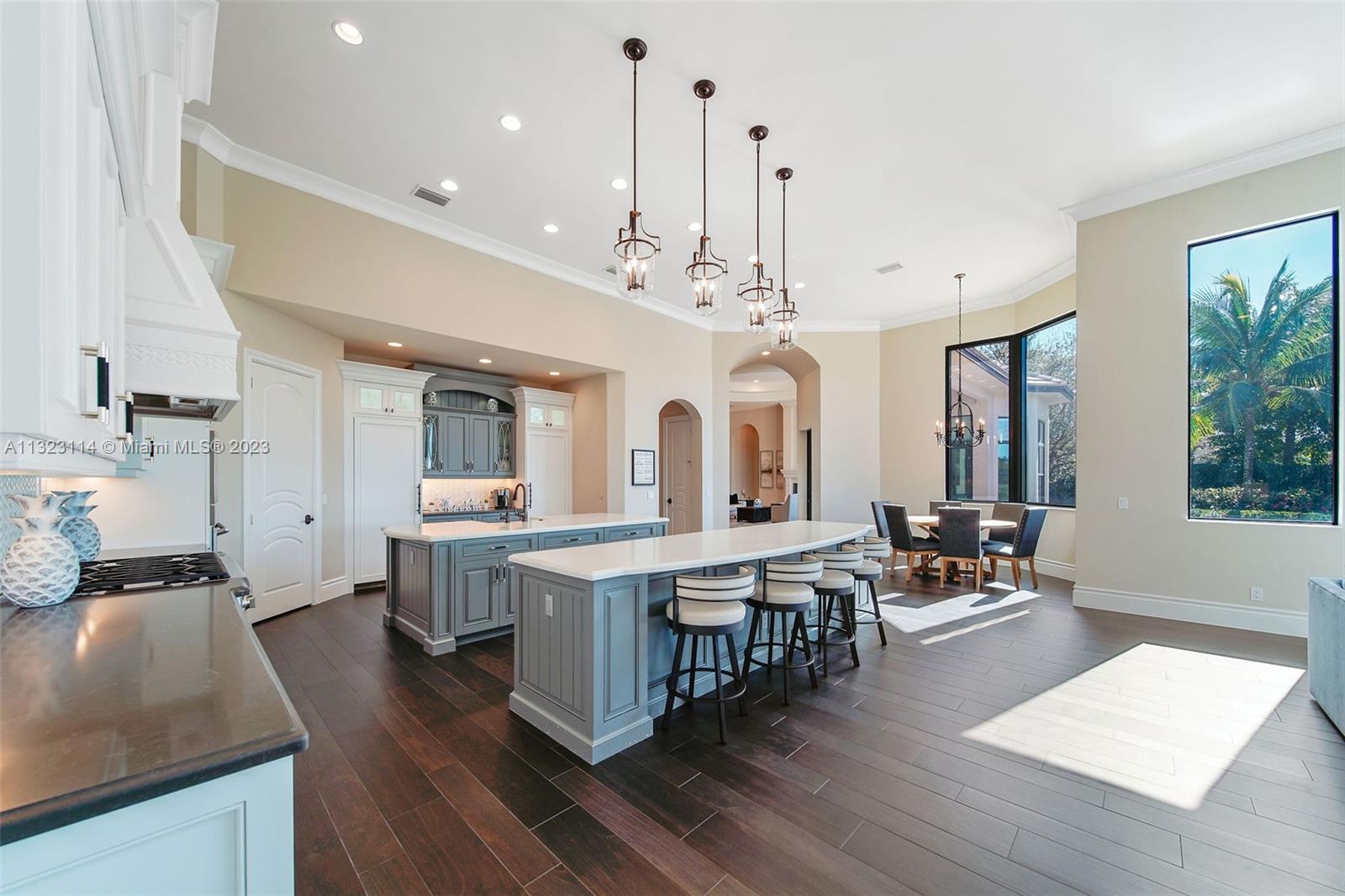 2863 Lake Ridge Lane Weston, FL 33332 - Photo 59 of 60 a large white kitchen with lots of counter space a sink appliances and dining table