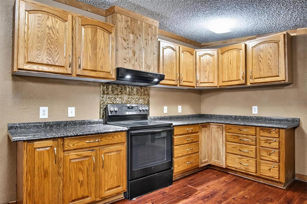 156 Kingfish Road Pomona Park, FL 32181 - Photo 29 of 55 a kitchen with stainless steel appliances granite countertop a stove and cabinets