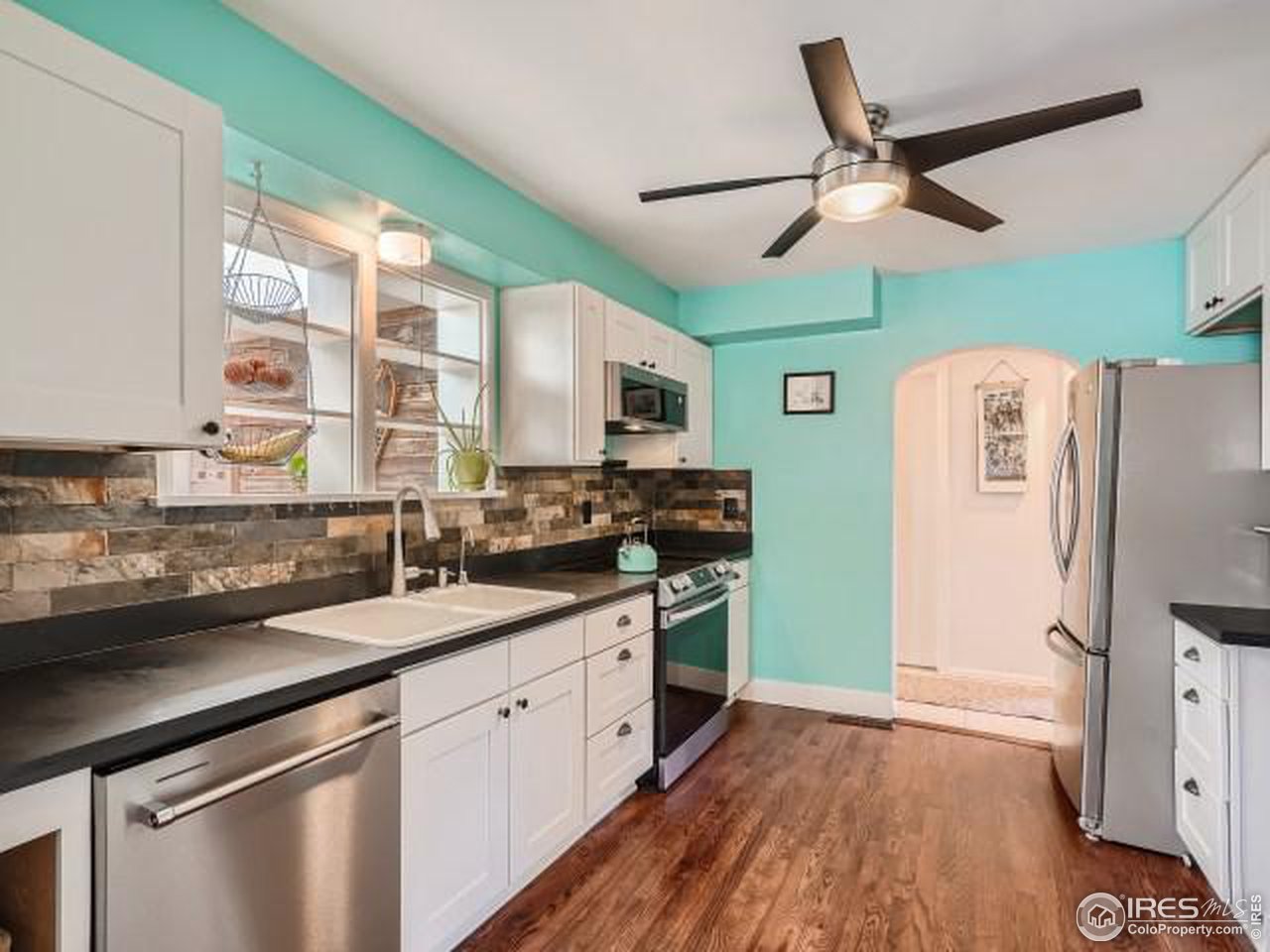 315 West Baseline Road Lafayette, CO 80026 - Photo 5 of 40 a kitchen with stainless steel appliances a sink cabinets and wooden floor