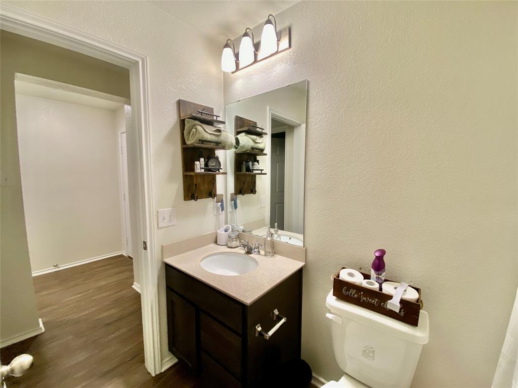 110 West Point Way Elgin, TX 78621 - Photo 12 of 19 A classic vanity setup features a dark wood cabinet paired with light countertops.