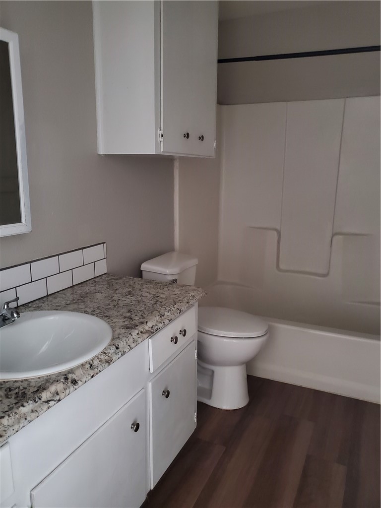 1102 Denver Street, Unit B Portland, TX 78374 - Photo 4 of 7 a bathroom with a granite countertop toilet sink and mirror