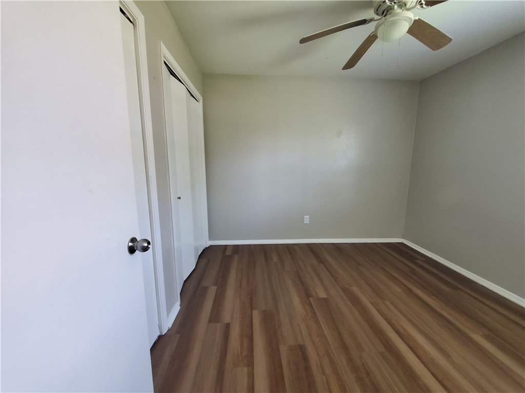1102 Denver Street, Unit B Portland, TX 78374 - Photo 6 of 7 an empty room with wooden floor and windows