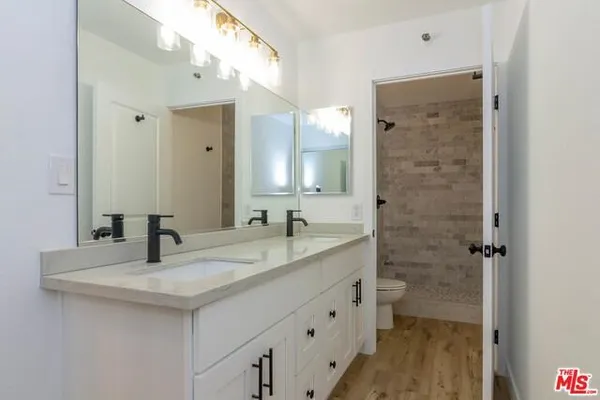 a bathroom with a granite countertop sink a mirror and a shower