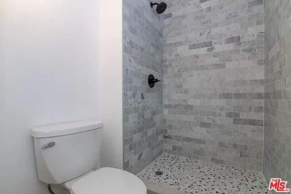 a white toilet sitting next to a shower