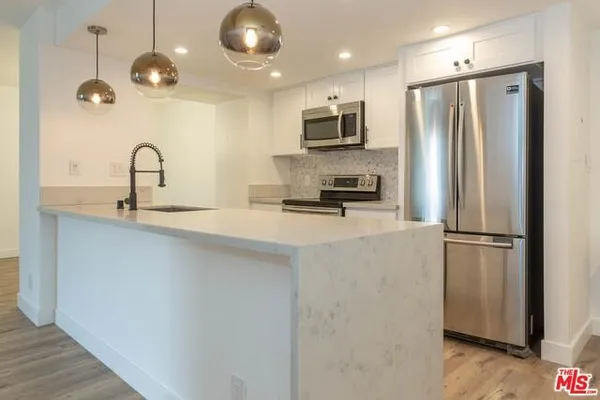 a kitchen with stainless steel appliances a refrigerator sink and microwave