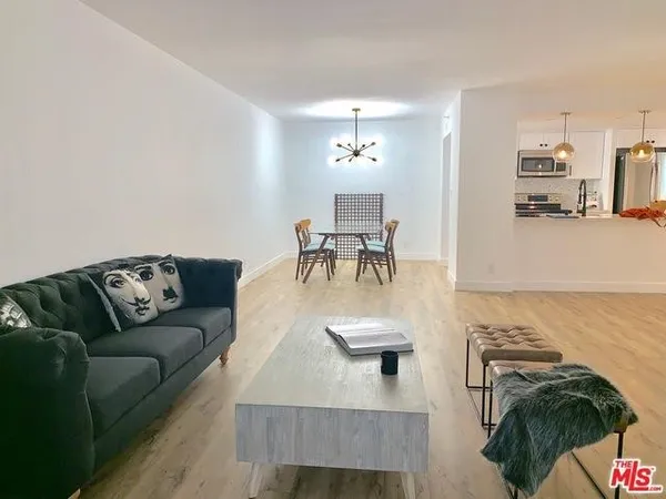 a living room with furniture and a dining table with kitchen view