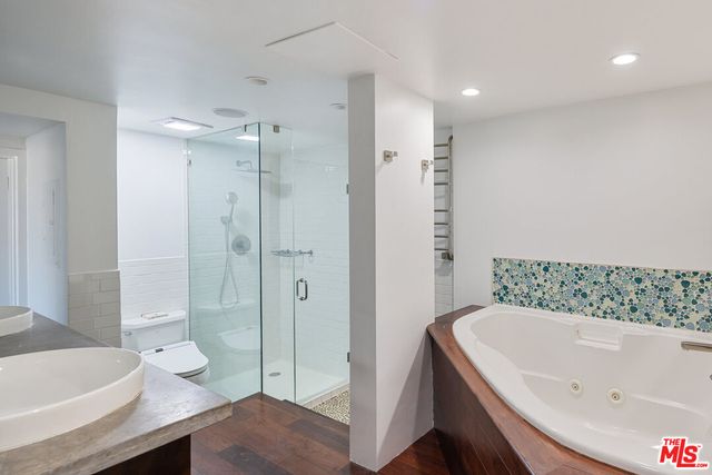 a bathroom with a tub a toilet and a shower