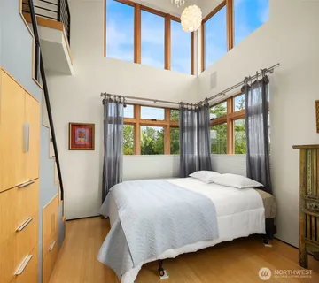 a bedroom with a bed window and a flat tv screen