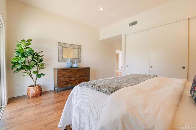 a bedroom with a bed and a potted plant