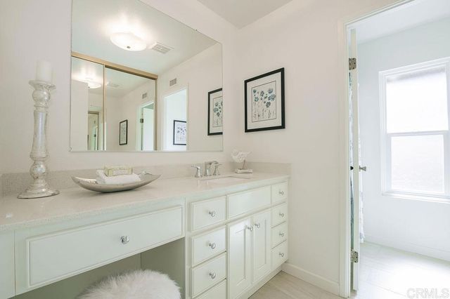 a bathroom with a granite countertop sink and a mirror