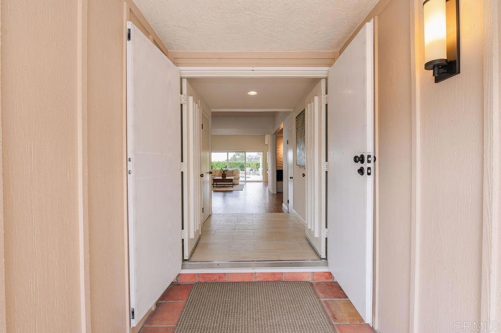 13321 Canyon Back Lane Poway, CA 92064 - Photo 3 of 26 a view of a hallway with wooden floor and a bathroom