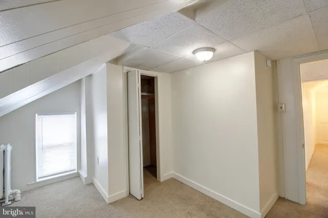 an empty room with windows and closet