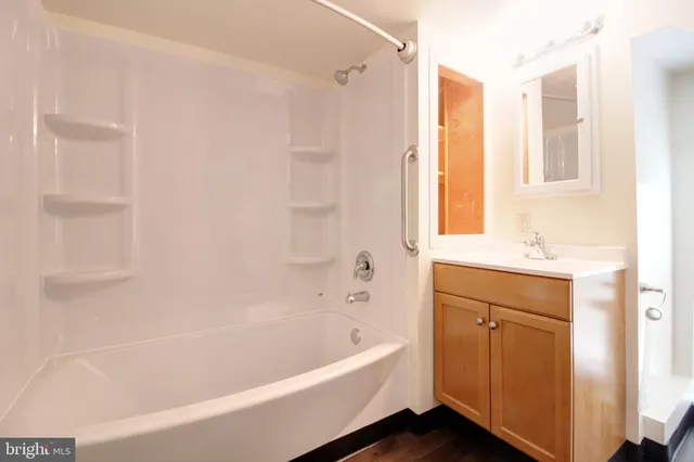 a white bath tub sitting next to a bathroom sink