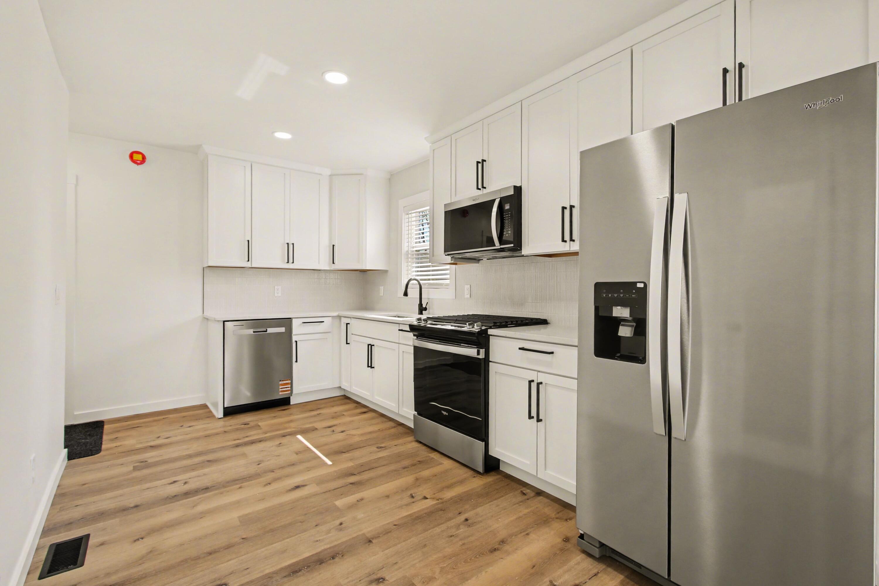 3517 Buchanan Street Gary, IN 46408 - Photo 4 of 18 a kitchen with white cabinets stainless steel appliances and a refrigerator