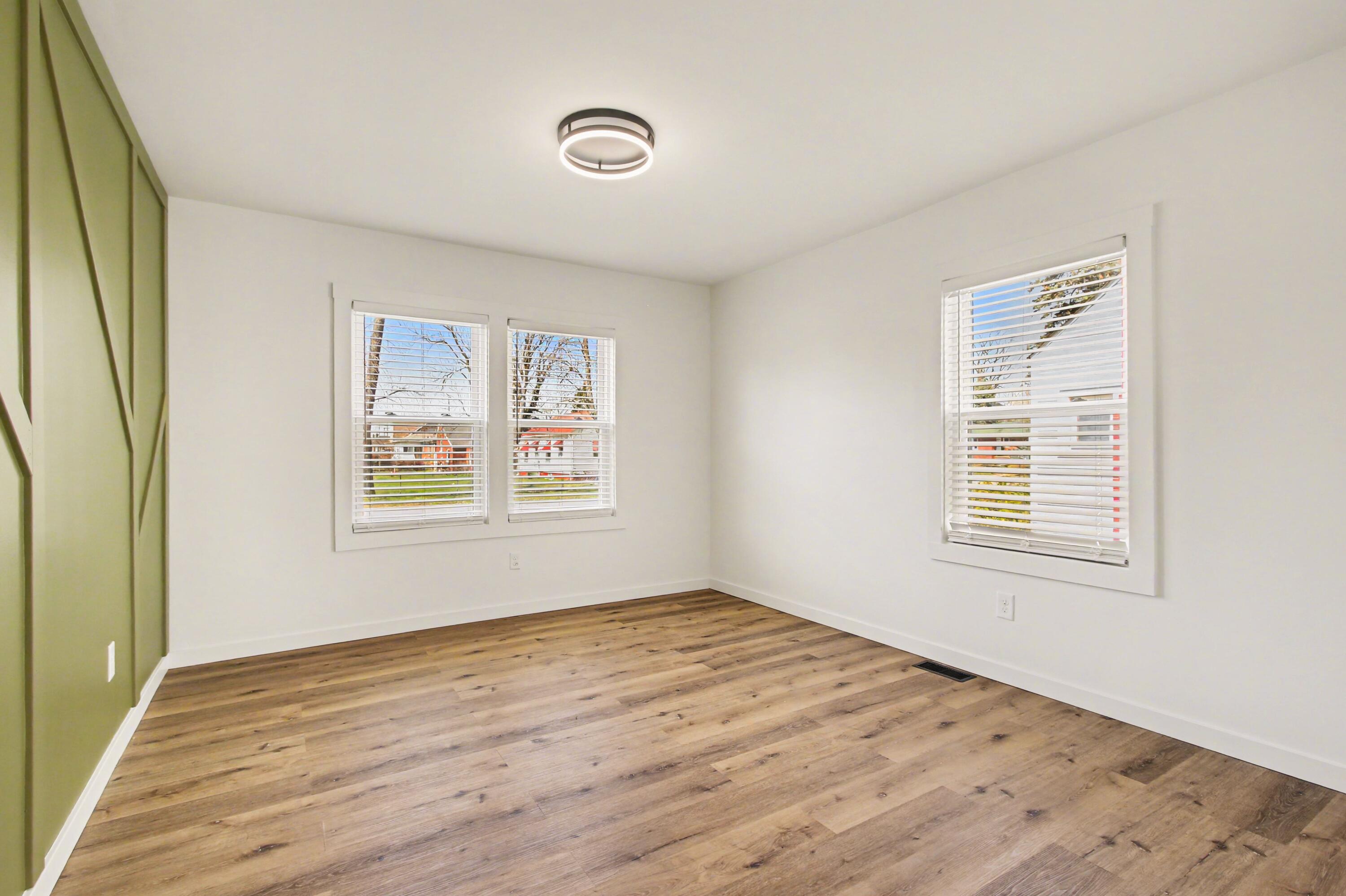 3517 Buchanan Street Gary, IN 46408 - Photo 8 of 18 a view of an empty room with wooden floor and a window