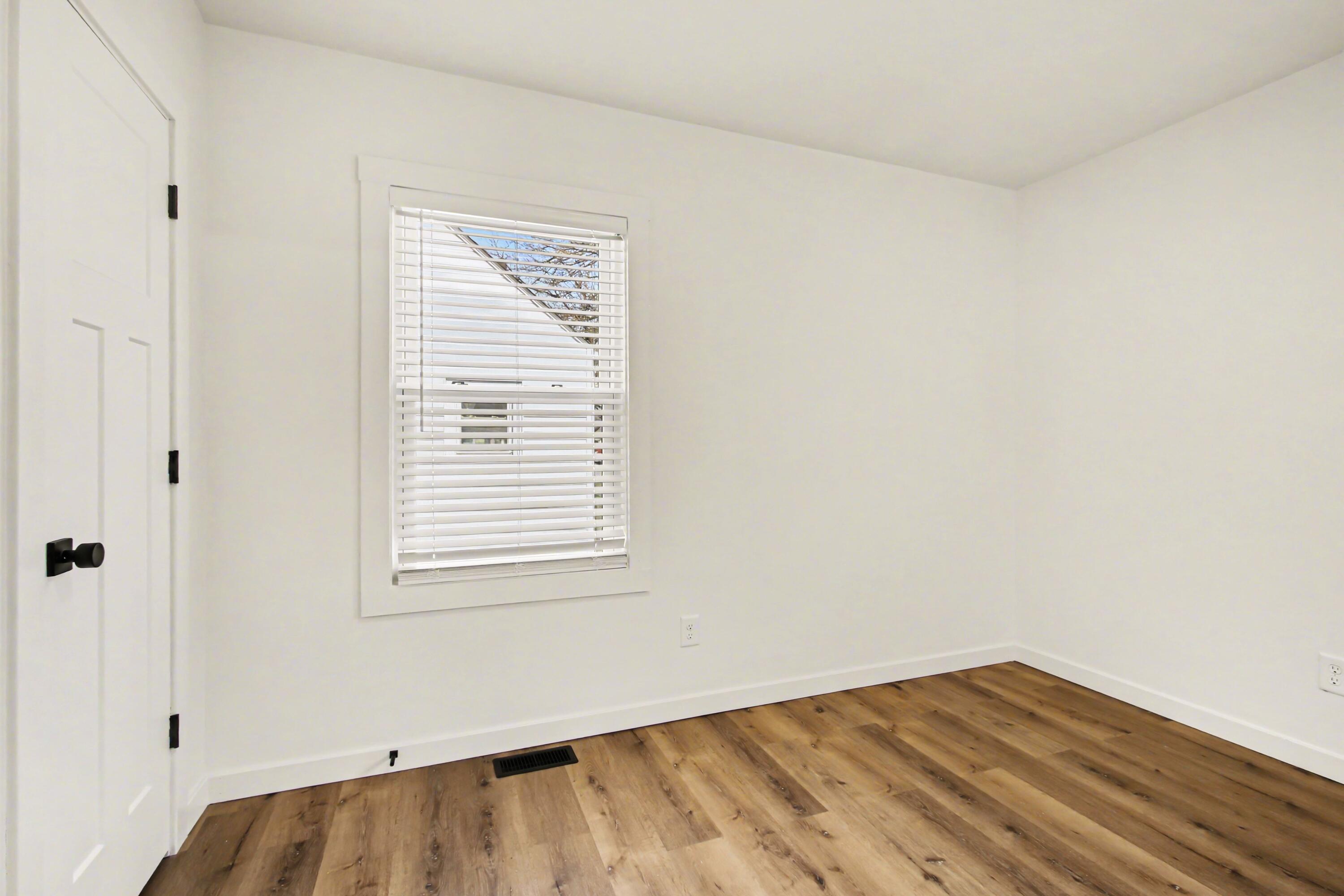 3517 Buchanan Street Gary, IN 46408 - Photo 10 of 18 a view of an empty room with wooden floor and a window