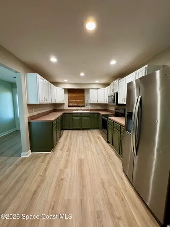 a kitchen with stainless steel appliances granite countertop a refrigerator and a sink