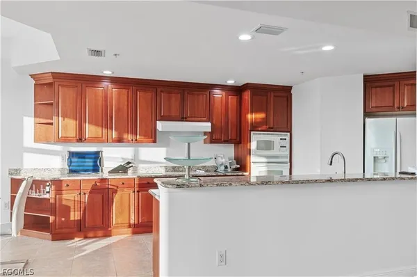a kitchen with stainless steel appliances granite countertop a sink a stove cabinets and a granite counter top