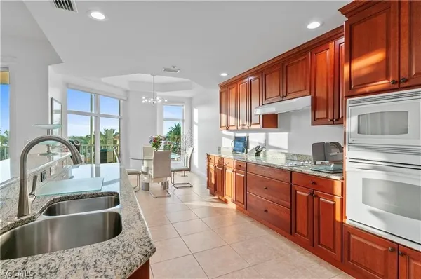 a kitchen with stainless steel appliances granite countertop a sink dishwasher stove and cabinets