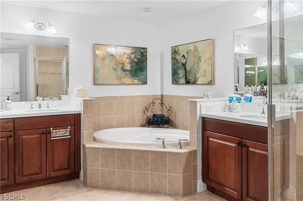 a bathroom with a tub a sink and mirror