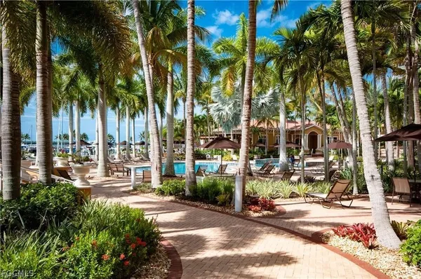 a row of palm trees and swimming pool in the backyard of a house