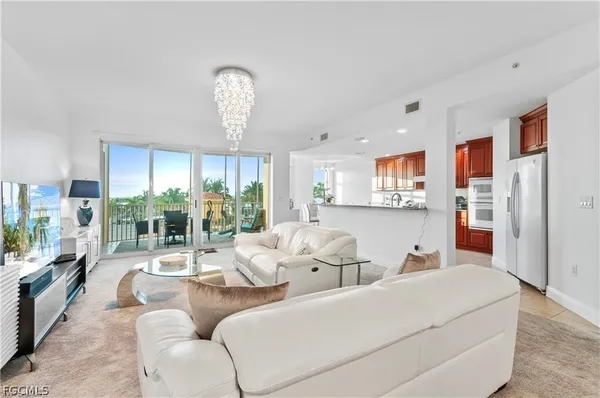 a living room with furniture and a chandelier