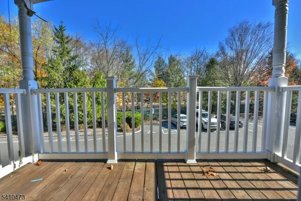 a view of a balcony with wooden floor and fence
