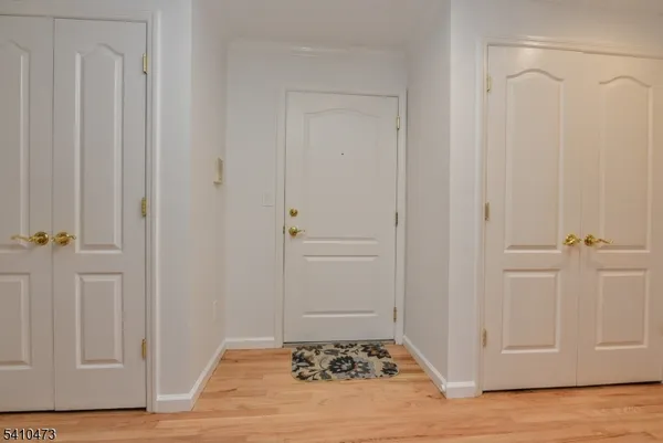 a view of a hallway with wooden floor and a carpet