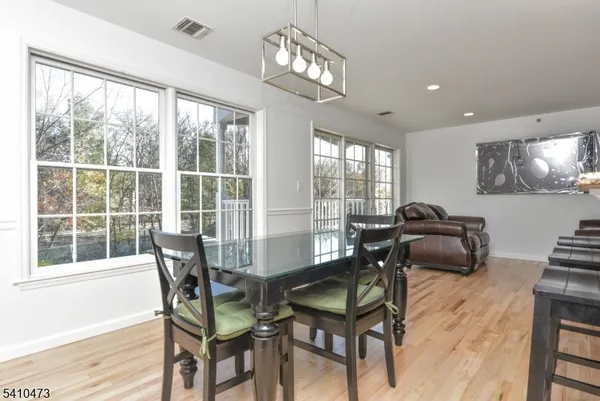 a dining room with furniture a chandelier and wooden floor