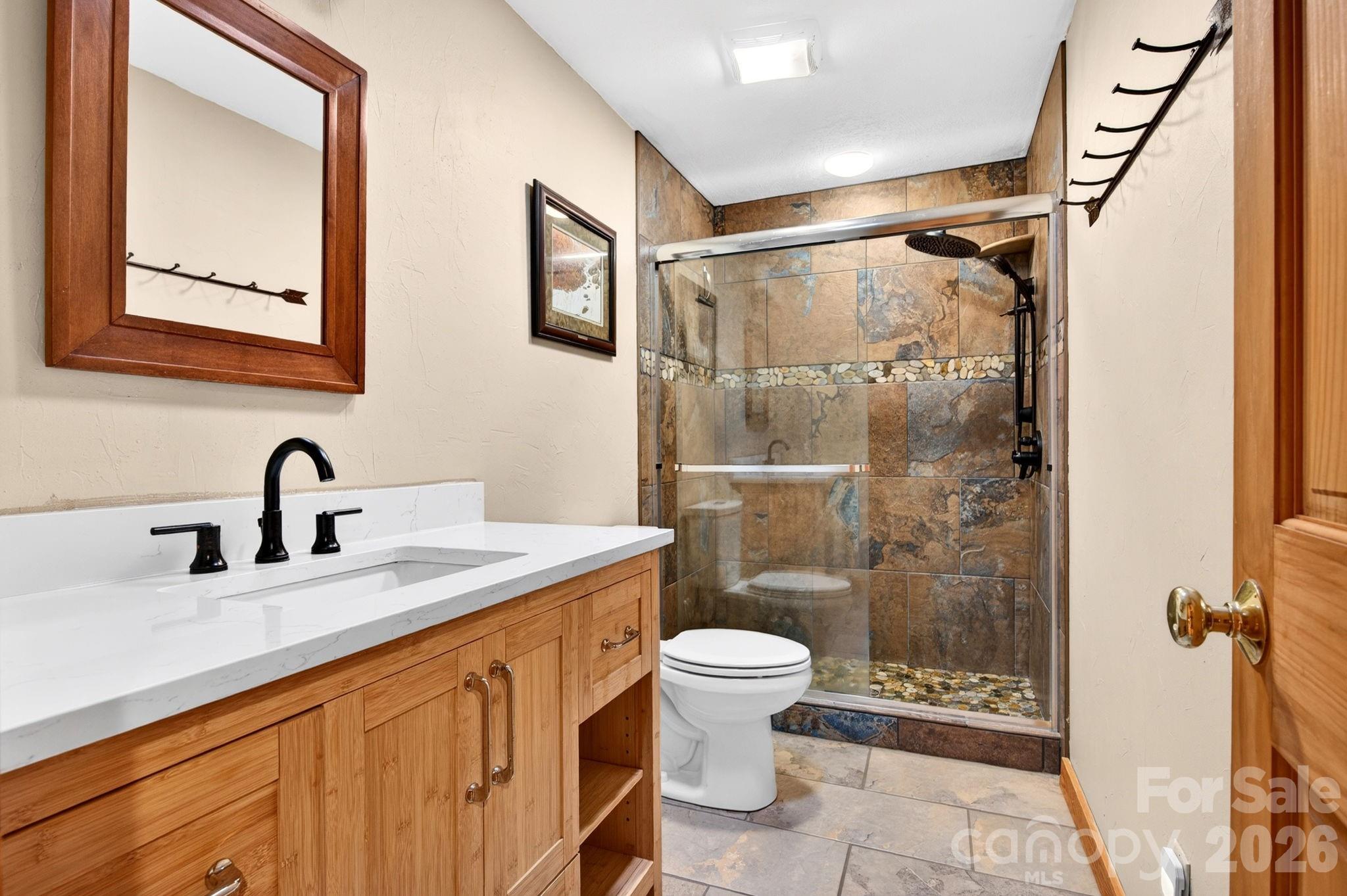 14 Weeping Cherry Forest Road Fairview, NC 28730 - Photo 21 of 44 a bathroom with a granite countertop sink toilet and shower
