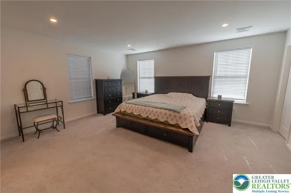 a bedroom with a bed a table and potted plant