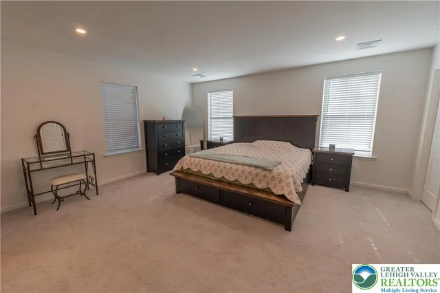 a bedroom with a bed a table and potted plant