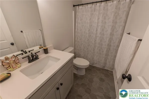 a bathroom with a sink a toilet and a mirror