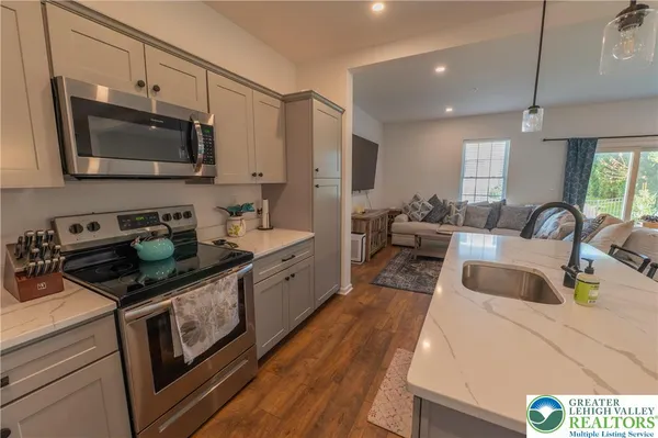 a kitchen with stainless steel appliances a stove a sink a microwave a refrigerator and cabinets