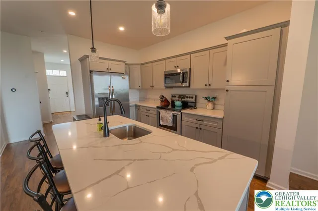 a kitchen with kitchen island a sink stainless steel appliances cabinets and a counter top space