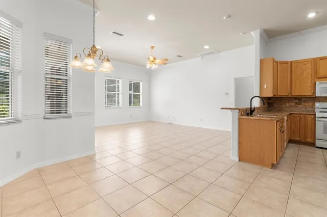 a view of a kitchen with a sink and dishwasher a refrigerator with white cabinets