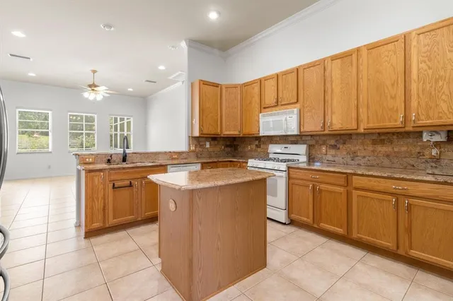 a kitchen with stainless steel appliances granite countertop a stove a sink and a microwave