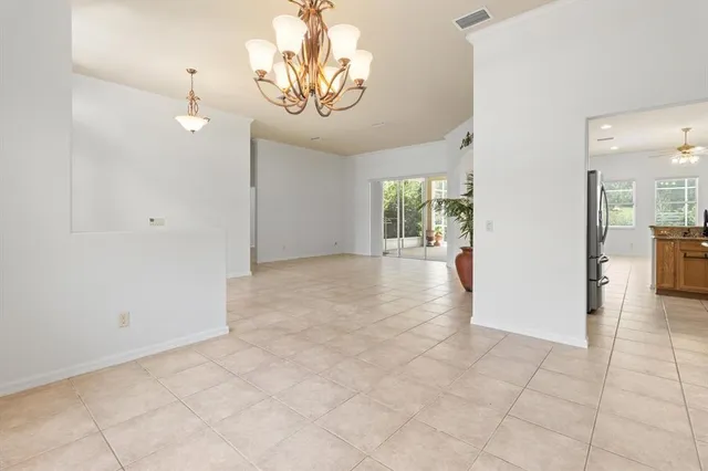 an empty room with chandelier and windows