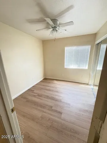 an empty room with a wooden floor and windows