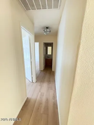 a view of a hallway with wooden floor