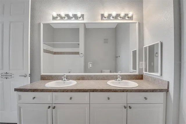 a bathroom with double sink and a mirror