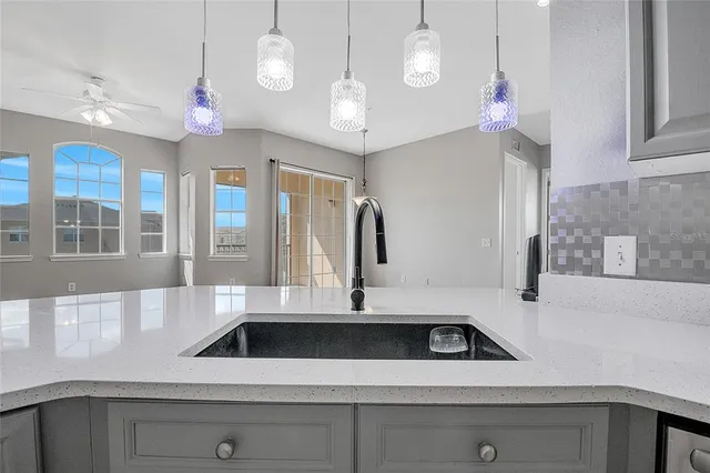 a view of a kitchen with a sink and chandelier