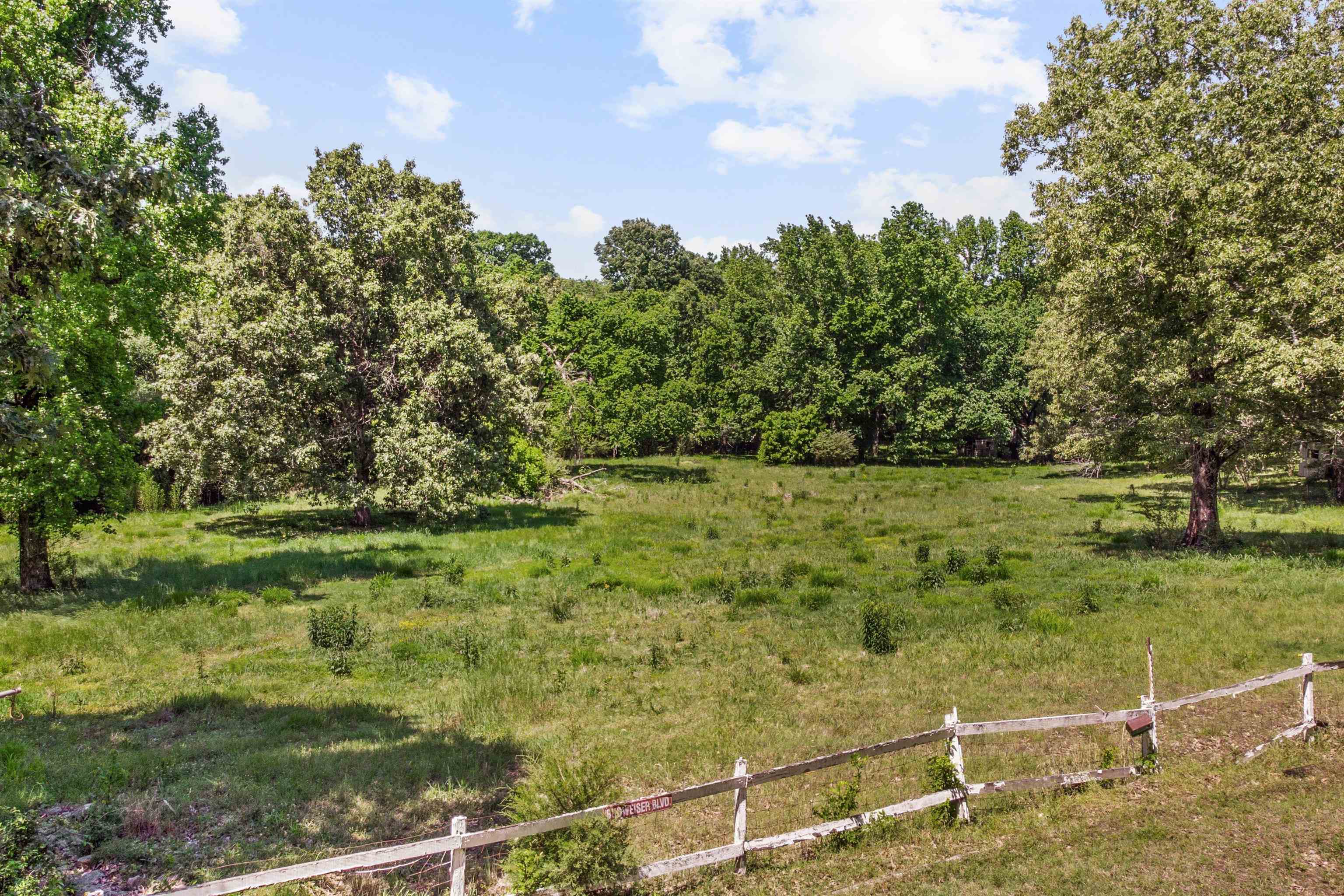 1147 North Collierville Arlington Road Collierville, TN 38017 - Photo 17 of 17 Expansive open field with scattered mature trees and a partial rustic wooden fence