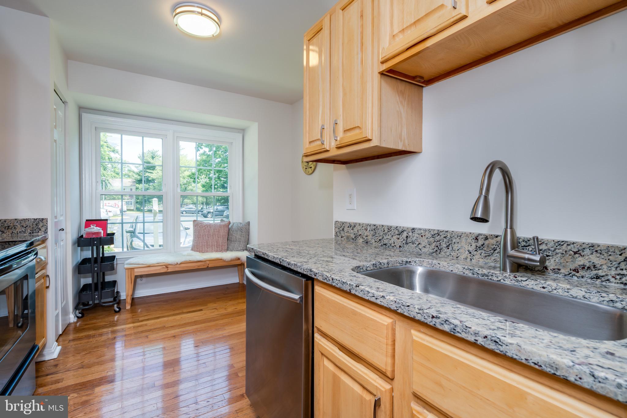 6490 Franconia Road Springfield, VA 22150 - Photo 10 of 34 a kitchen with stainless steel appliances granite countertop a sink dishwasher and cabinets with wooden floor