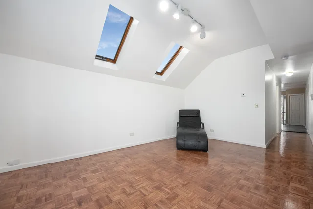 an empty room with stairs and wooden floor