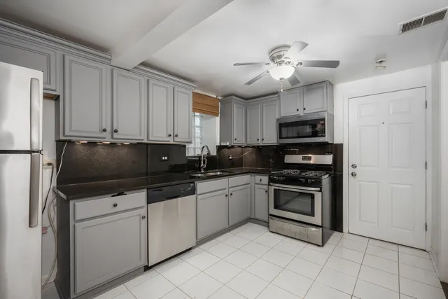 a kitchen with stainless steel appliances a stove microwave and a refrigerator